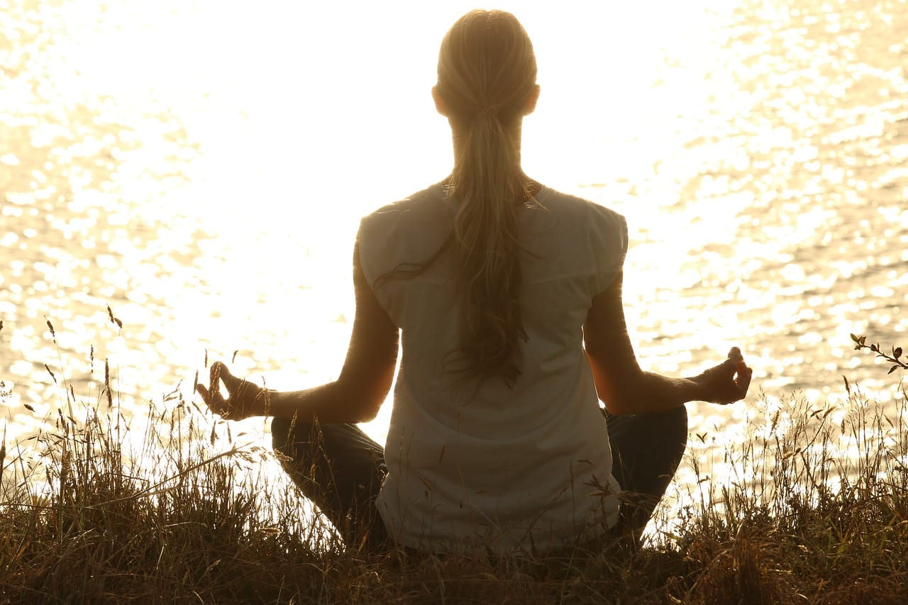 Female meditator by the water