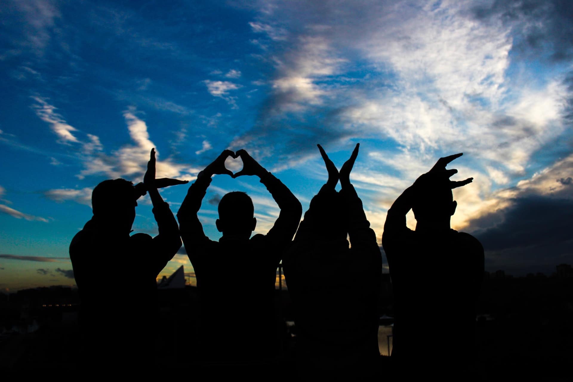 Four pairs of hands spelling the word LOVE